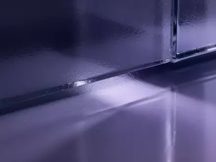 Nahaufnahme von mattiertem, durchscheinendem Glas mit sanften violett-indigo Lichtreflexen, die Tiefe erzeugen. - Foto: über boerse-global.de