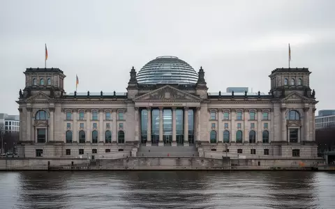Das Gebäude des Deutschen Bundestages unter einem bewölkten Himmel mit Blick auf die Glaskuppel. - Foto: über boerse-global.de