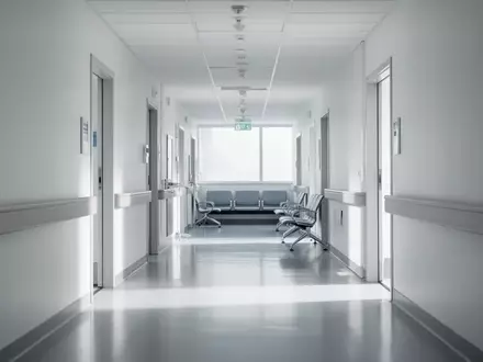 Ein leerer, modern gestalteter Krankenhausflur mit hellen Wänden und neutraler Beleuchtung. - Foto: über boerse-global.de