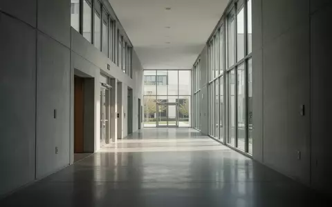Moderner, minimalistischer Flur in einem Behördengebäude mit neutralen Wänden und Tageslichteinfall. - Foto: über boerse-global.de