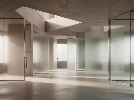Abstraktes, minimalistisches Architektur-Interieur mit klaren Linien und diffusem Licht, das Sicherheit und Ordnung symbolisiert. - Foto: über boerse-global.de