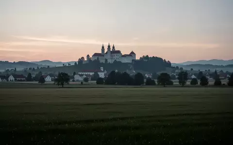 Weite, ruhige Landschaft im österreichischen Melk bei Dämmerung mit der Silhouette der Stiftskirche im Hintergrund. - Foto: über boerse-global.de