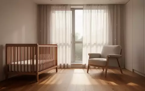 Ein ruhiges, lichtdurchflutetes Kinderzimmer mit einem leeren Holzbettchen und einem Sessel in einer modernen, minimalistischen Einrichtung. - Foto: über boerse-global.de