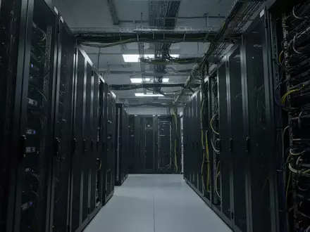 Reihen von dunklen Serverschränken in einem modernen Rechenzentrum bei gedimmter Beleuchtung. - Foto: über boerse-global.de