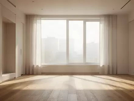 Ein helles, minimalistisch eingerichtetes Wohnzimmer mit einfallendem Tageslicht und weichen Schatten auf einem Holzboden. - Foto: über boerse-global.de