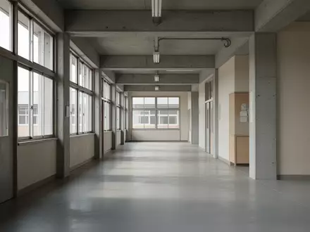 Leerer, minimalistischer Schulflur mit Sichtbeton und großen Fenstern bei natürlichem Tageslicht. - Foto: über boerse-global.de