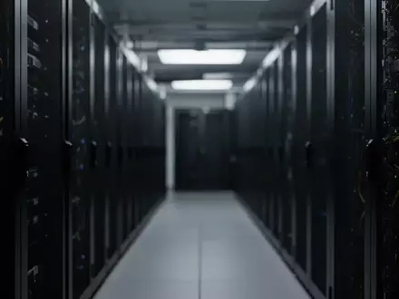 Dunkler Serverraum mit verschwommenen Rack-Schränken in kühler, technischer Atmosphäre. - Foto: über boerse-global.de