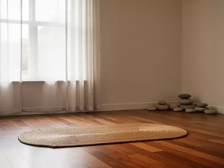 Ein minimalistisch eingerichteter Raum mit einer leeren Meditationsmatte auf einem Holzboden und sanftem Tageslicht. - Foto: über boerse-global.de