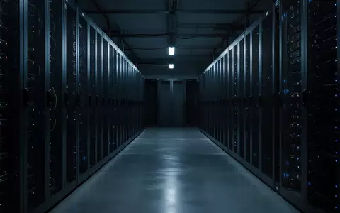 Dunkler, minimalistischer Serverraum mit unbeleuchteten Server-Racks und blauem Umgebungslicht auf einem Betonboden. - Foto: ĂŒber boerse-global.de