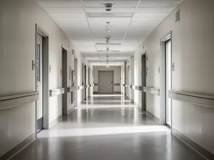 Ein minimalistischer, leerer Krankenhausflur mit neutralen Farben und klaren architektonischen Linien bei natürlichem Licht. - Foto: über boerse-global.de