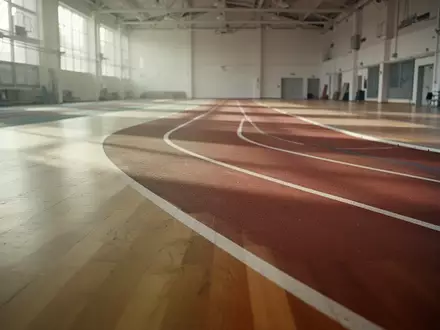 Eine leere, minimalistische Laufbahn in einer hellen Sporthalle mit natürlichem Lichteinfall. - Foto: über boerse-global.de