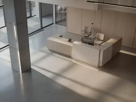 Ein minimalistischer, leerer Empfangsbereich in einem modernen Bürogebäude mit architektonischen Schatten. - Foto: über boerse-global.de