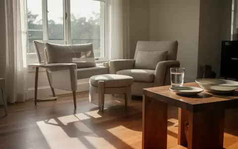Ein helles, modern eingerichtetes Wohnzimmer mit einem bequemen Sessel in der Nähe eines Fensters bei natürlichem Lichteinfall. - Foto: über boerse-global.de