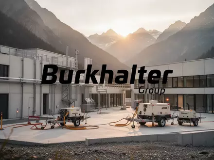 Moderne Baustelle und Infrastruktur-Engineering vor einer alpinen Gebirgskulisse bei Sonnenuntergang. - Foto: über boerse-global.de