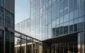 Moderne Glasfassade eines Bürogebäudes bei klarem Himmel als Symbol für wirtschaftliche Expansion und Unternehmensstrukturen. - Foto: über boerse-global.de