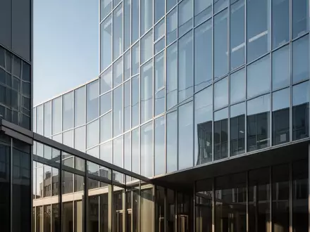 Moderne Glasfassade eines Bürogebäudes bei klarem Himmel als Symbol für wirtschaftliche Expansion und Unternehmensstrukturen. - Foto: über boerse-global.de