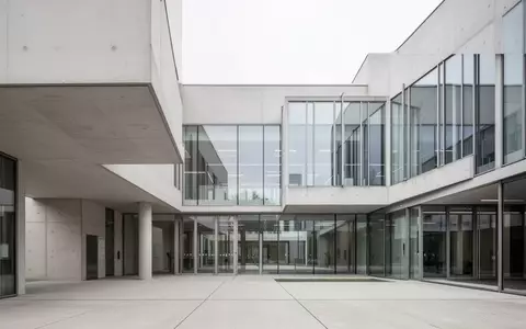 Modernes Verwaltungsgebäude mit schlichter Architektur und Glasfassade bei Tageslicht. - Foto: über boerse-global.de