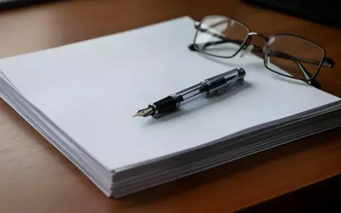 Symbolbild: Papierstapel, Füller und Brille auf dem Schreibtisch - Foto: über boerse-global.de