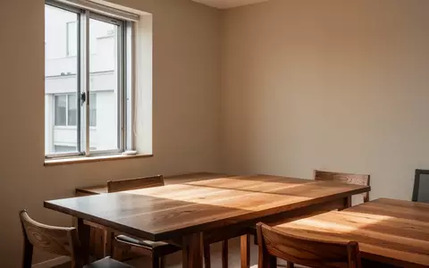 Ein heller, minimalistischer Raum mit einem Holztisch, der eine ruhige und sachliche Atmosphäre vermittelt. - Foto: über boerse-global.de