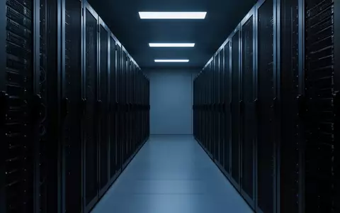 Ein minimalistischer, dunkel beleuchteter Serverraum mit metallischen Schaltschränken in einer sterilen, industriellen Umgebung. - Foto: über boerse-global.de