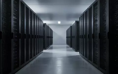 Ein minimalistischer, modern gestalteter Serverraum mit dunklen, industriellen Rack-Systemen und kühler Lichtstimmung. - Foto: über boerse-global.de