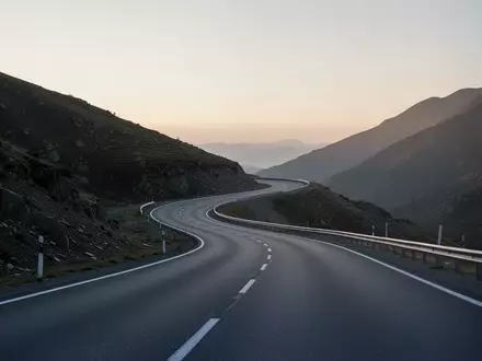 Eine leere, geschwungene Landstraße bei Dämmerung, die die Veränderung in der Kfz-Versicherungslandschaft symbolisiert. - Foto: über boerse-global.de