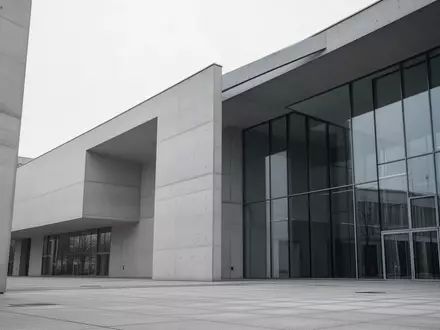 Ein minimalistisches, modernes Regierungsgebäude in Berlin bei bewölktem Himmel, das Stabilität und institutionelle Last symbolisiert. - Foto: über boerse-global.de