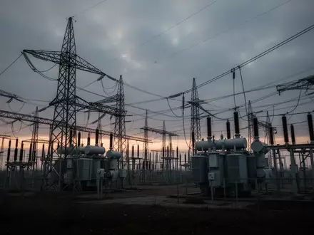 Ein Hochspannungsumspannwerk mit großen Stahltürmen und Transformatoren bei Dämmerung in einer weitläufigen Industrielandschaft. - Foto: über boerse-global.de