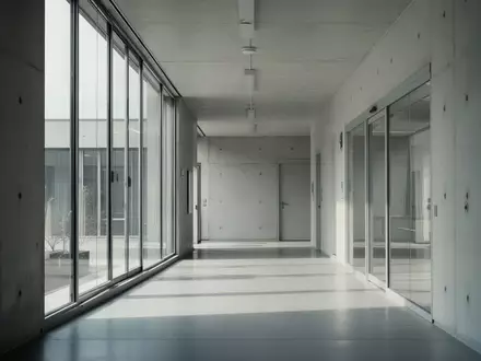 Ein minimalistischer, leerer Flur in einem modernen Verwaltungsgebäude mit hellem Tageslicht. - Foto: über boerse-global.de
