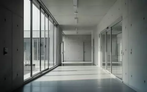 Ein minimalistischer, leerer Flur in einem modernen Verwaltungsgebäude mit hellem Tageslicht. - Foto: über boerse-global.de