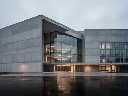 Ein minimalistisches, modernes Verwaltungsgebäude vor einem bewölkten Himmel in der Dämmerung. - Foto: über boerse-global.de