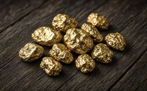 Rohe Goldnuggets auf einem dunklen Holztisch - Foto: über boerse-global.de