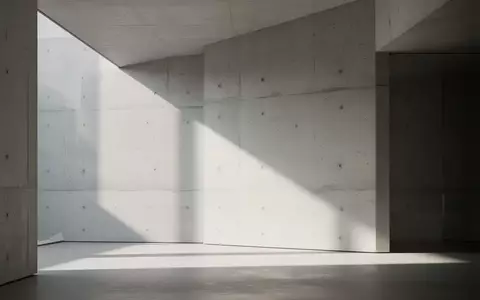 Ein minimalistischer, lichtdurchfluteter moderner Innenraum mit klaren geometrischen Linien und weichen Schatten auf einer Betonwand. - Foto: über boerse-global.de
