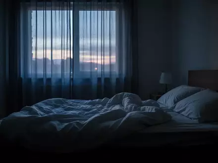 Ein ungemachtes Bett in einem abgedunkelten Schlafzimmer im sanften Licht des frühen Morgens. - Foto: über boerse-global.de