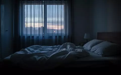Ein ungemachtes Bett in einem abgedunkelten Schlafzimmer im sanften Licht des frühen Morgens. - Foto: über boerse-global.de
