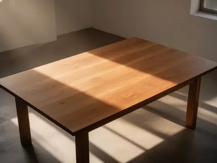 Ein minimalistischer, leerer Holztisch in einem hellen Raum mit sanftem Lichteinfall, der eine Atmosphäre der Ruhe und Besonnenheit vermittelt. - Foto: über boerse-global.de