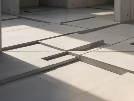 Minimalistische architektonische Komposition mit geometrischen Linien und geordneten Abständen auf einer Betonoberfläche. - Foto: über boerse-global.de