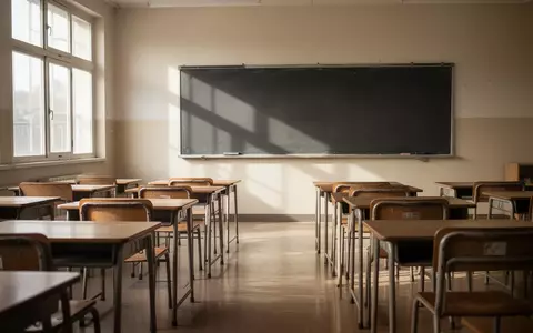 Ein leerer, sonnendurchfluteter Grundschulklassenraum mit ordentlich aufgereihten Holztischen und Stühlen. - Foto: über boerse-global.de