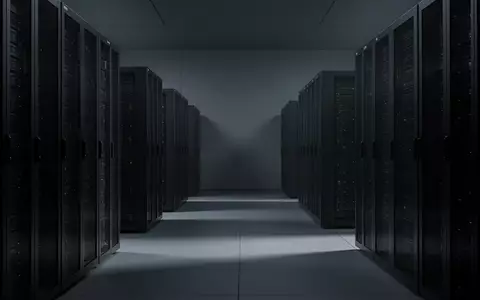 Dunkle, symmetrisch angeordnete Server-Racks in einem modernen Rechenzentrum, beleuchtet durch kühles, atmosphärisches Licht. - Foto: über boerse-global.de