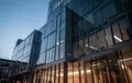Moderne Glasfassade eines Bankgebäudes in Frankfurt bei Dämmerung mit Fokus auf Architektur und klaren Linien. - Foto: über boerse-global.de