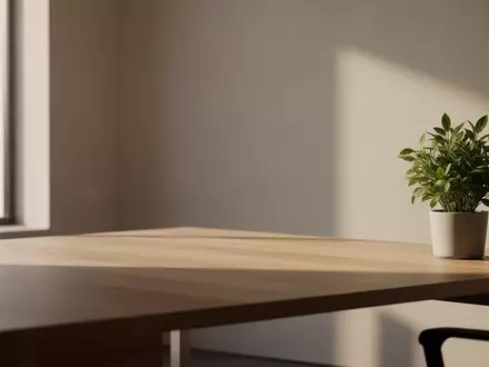 Ein minimalistischer, aufgeräumter Arbeitsplatz mit einem hölzernen Schreibtisch, einer Zimmerpflanze und weichem Tageslicht. - Foto: über boerse-global.de