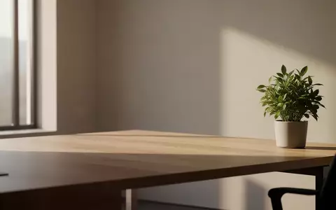 Ein minimalistischer, aufgeräumter Arbeitsplatz mit einem hölzernen Schreibtisch, einer Zimmerpflanze und weichem Tageslicht. - Foto: über boerse-global.de