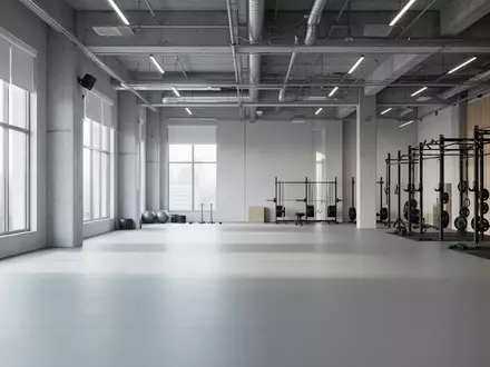 Ein minimalistisch gestalteter, leerer Fitnessraum mit modernem Industriedesign und hellem Tageslicht. - Foto: über boerse-global.de
