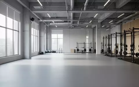 Ein minimalistisch gestalteter, leerer Fitnessraum mit modernem Industriedesign und hellem Tageslicht. - Foto: über boerse-global.de