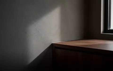 Ein minimalistisch eingerichtetes Hotelzimmer mit Fokus auf Wandtexturen und Lichtschatten in einer Raumecke. - Foto: über boerse-global.de