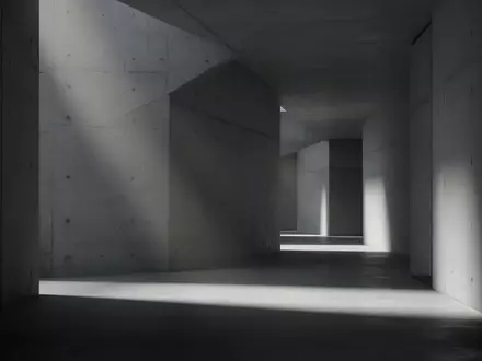 Ein minimalistischer, modern gestalteter Flur mit Betonwänden und diffusem Licht, der eine ruhige und nachdenkliche Stimmung erzeugt. - Foto: über boerse-global.de