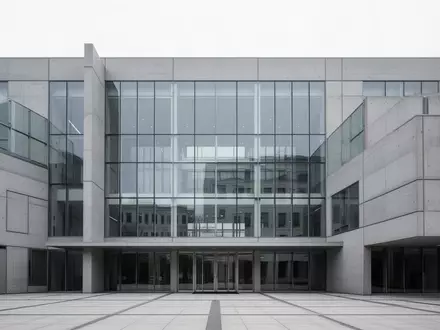 Moderne Fassade eines Verwaltungsgebäudes aus Glas und Beton bei Tageslicht. - Foto: über boerse-global.de