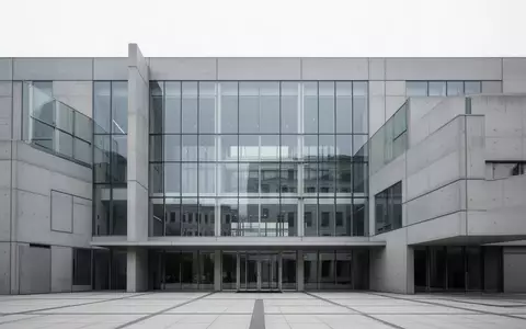Moderne Fassade eines Verwaltungsgebäudes aus Glas und Beton bei Tageslicht. - Foto: über boerse-global.de