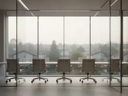 Ein minimalistischer, moderner Büroraum mit großen Glasfronten und Blick auf eine ruhige Landschaft bei natürlichem Licht. - Foto: über boerse-global.de