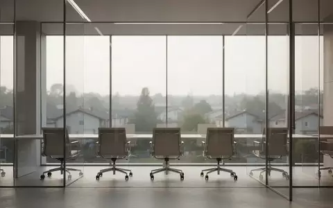 Ein minimalistischer, moderner Büroraum mit großen Glasfronten und Blick auf eine ruhige Landschaft bei natürlichem Licht. - Foto: über boerse-global.de